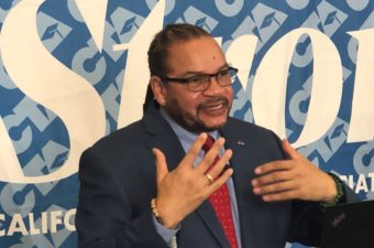 CTA President Toby Boud speaks in front of a blue Union Strong banner.